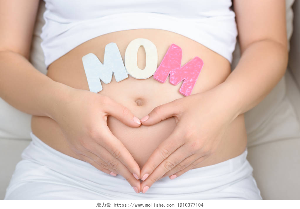 孕妇在她的肚子上比划的爱心孕妇与妈妈词